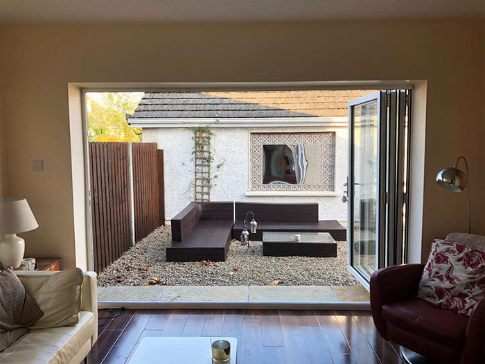 Open white upvc bi folding doors leading to a garden seating area